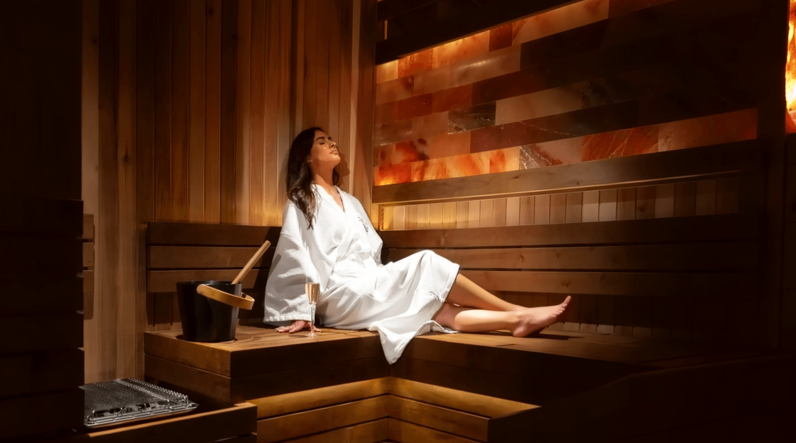 A woman in a white robe relaxing in a sauna